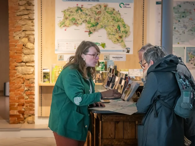 Reiseberaterin, die Besuchern am Empfang von Alençon Tourisme Auskunft gibt