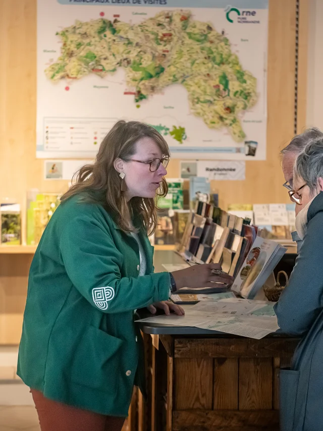 Conseillère en séjour renseignant des visiteurs à l'accueil d'Alençon Tourisme